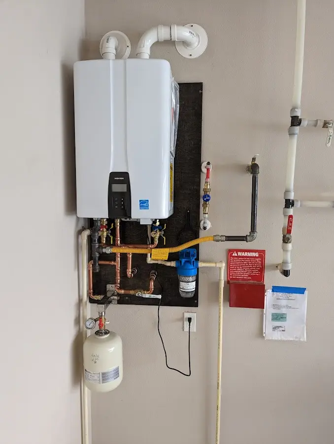 Professional plumber installing copper piping in a Welsh home